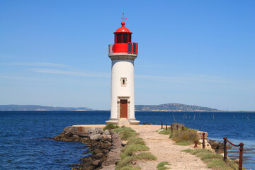 Fototapeta na wymiar Onglous lighthouse in Marseillan, a seaside resort in the Herault department in southern France