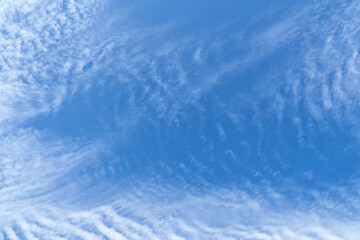 Blue sky with white, soft clouds. Natural white and blue background. The texture of the clouds.