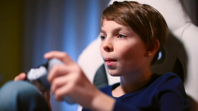 Close-up on the face of a teenager playing a video game ps4. Uses the controller with his hands. Facial expressions during internal experiences. Emotional relief.