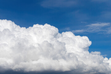Naklejka na ściany i meble Big white fluffy cumulus cloud against blue sky background.