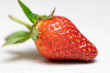 Juicy berry strawberry close-up. Macro shot of a fruit. Red-yellow photo.