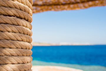 beach umbrella rewound with rope close-up on the background of the seascape
