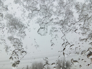 Snow melts on glass