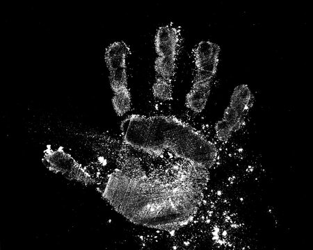 handprint from flour on a black background