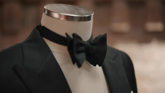 Closeup view of bow tie and black jacket are on mannequin at modern interior.