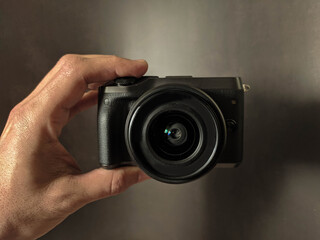 black photocamera in hand background