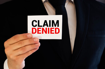 Businessman holding a card with text Claim Denied