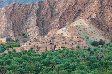 Fototapeta na wymiar Palm trees and a traditional mountain village in Nizwa,Oman.