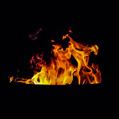 Flames of a firepit in the evening.  Yellow, Orange, and Red flames surrounded by darkness and shadows.