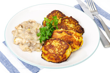 Fried grated potato pancakes with mushroom sauce. Studio Photo
