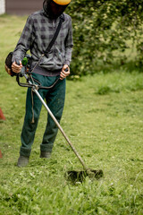 Man mowing the lawn in his garden. Gardener cutting the grass. Lifestyle.