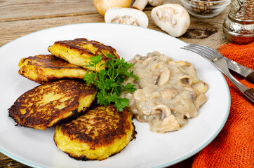 Fried grated potato pancakes with mushroom sauce. Studio Photo