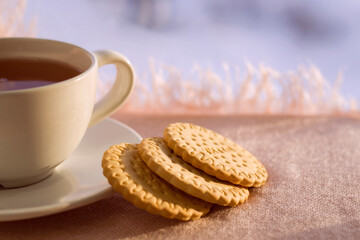cup of tea and round biscuits near the window with snow view - still life, winter warm background