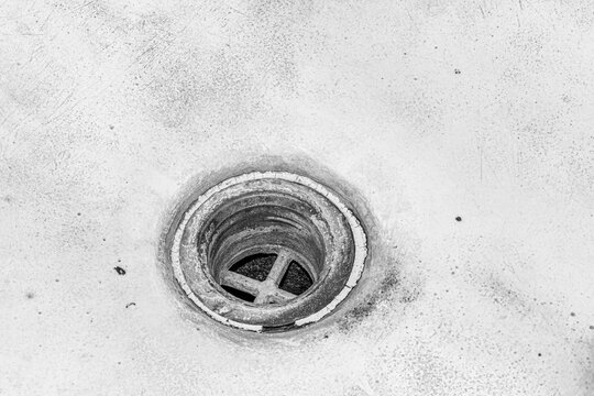 Terrible drain hole in the bathroom. Unsanitary condition of bath element close-up. Plumbing abstract background