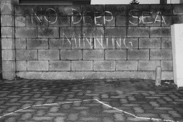 Anti deep water ming message in chalk on wall.