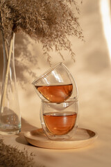 Double-bottom glasses are stacked on top of each other. Natural motives in warm colors. Breakfast glasses with tea.