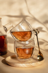 Double-bottom glasses are stacked on top of each other. Natural motives in warm colors. Breakfast glasses with tea. A spoon in the shape of a leaf. 