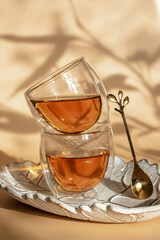 Double-bottom glasses are stacked on top of each other. Natural motives in warm colors. Breakfast glasses with tea.
