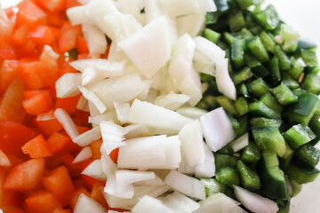 Sliced green peppers, red peppers, and onions