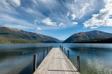 The jetty at Lake Rotoiti, Nelson Lakes National Park, New Zealand. Mountains and sky reflected in the lake.