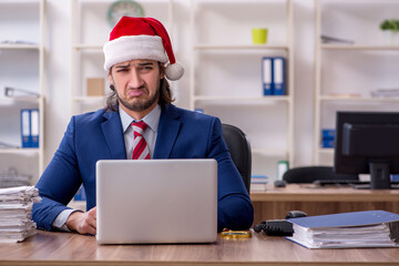 Young male employee working in the office at Christmas Eve