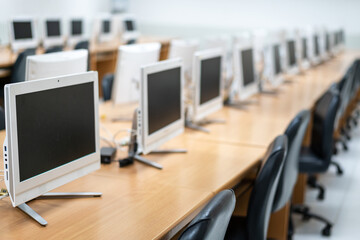 Blur and selective focus of desktop monitors well arranged in the computer room. Computers in the classroom in high school. The empty computer room at the elementary school