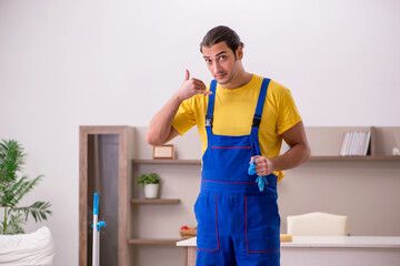 Young male contractor cleaning the house