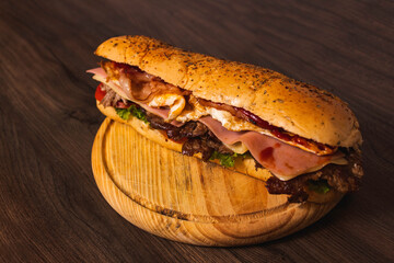 A giant and delicious tenderloin sandwich on top of a wooden plate.