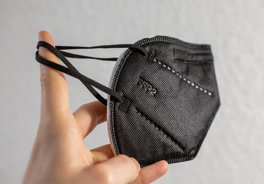 03.02.2021, FFP2-Masken. Eine schwarze FFP2-Maske wird vor einen wei&szlig;en Hintergrund gehalten.