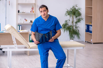 Young male doctor radiologist being unhappy after night shift