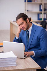Fototapeta premium Young male employee and too much work in the office