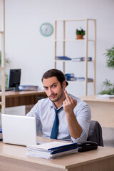 Young male bookkeeper working in the office