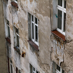 Fototapeta na wymiar Old and ruined house facade, dirt and broken windows