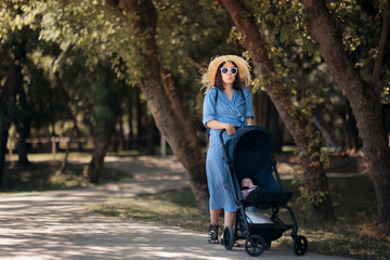 Happy Mother Walking Baby Outdoors in Stroller