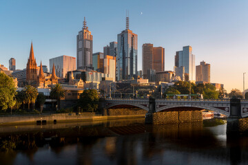 Fototapeta na wymiar Golden light. Melbourne skyline at sunrise. Beautiful view of the city from the river bank, early morning