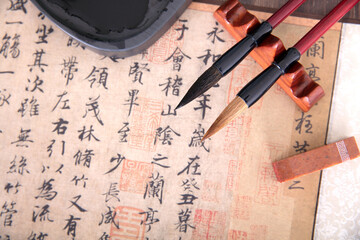 Calligraphy works, inkstones, brushes and a seal are spread out on the table