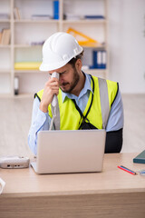 Young arm injured male architect working in the office