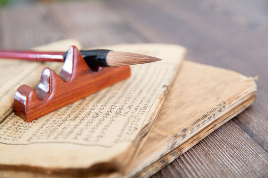 The ancient books opened and the writing brush on the pen holder