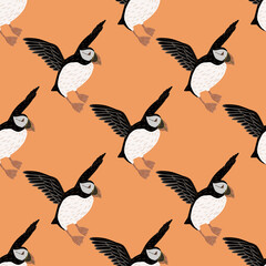 Cartoo seabird seamless pattern with hand drawn puffin birds silhouettes. Pastel orange background.