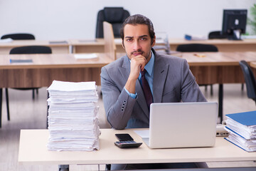Naklejka premium Young male employee unhappy with excessive work in the office