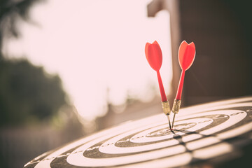 Close-up the bullseye target or dart board has red dart arrow throw hitting the center of a...