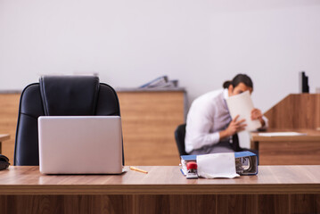 Young male employee stapling paper in the office