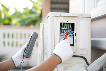Close up technician hand using measuring equipment checking electric current voltage at circuit...