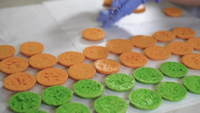 We spread the ready-made macarons on the table next to each other in orange and green. small business bakery concept
