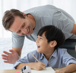 Fototapeta premium Father playing with mixed-race son with happy and joyful in home