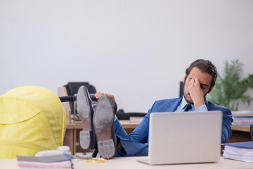 Young male employee looking after new born at workplace