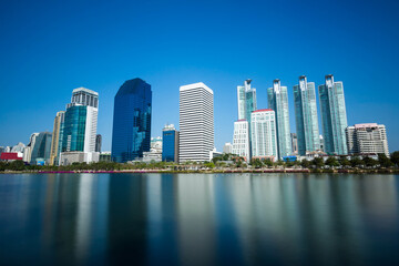 Fototapeta na wymiar Reflection Of Buildings In City Against Blue Sky