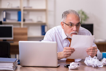 Old male employee in paper recycling concept