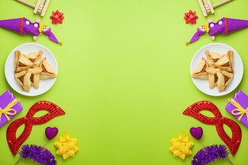 Jewish holiday Purim concept with carnival mask and hamantaschen cookies on green background