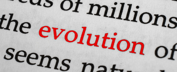Selective focus on the red word evolution. Macro shot printed red colour word Evolution on a piece of paper.